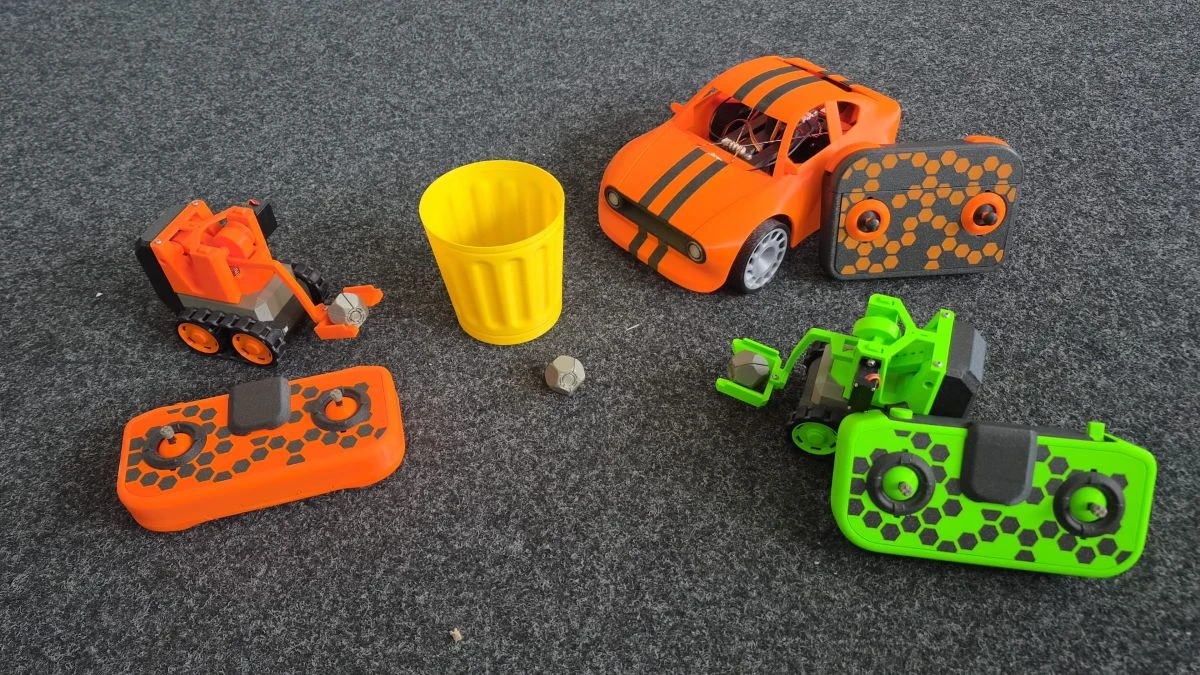 Verschiedene CyberBrick-Modelle mit Fernsteuerungen, darunter Fahrzeuge und ein Roboter.